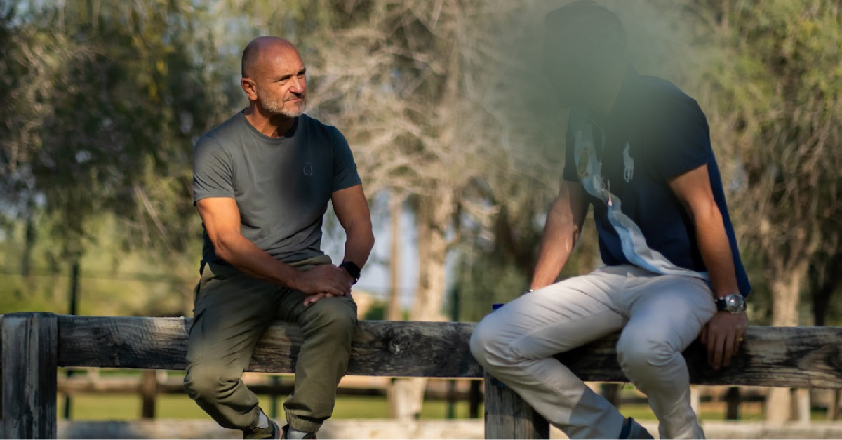 David Singleton coaching a client on a fence rail outdoors